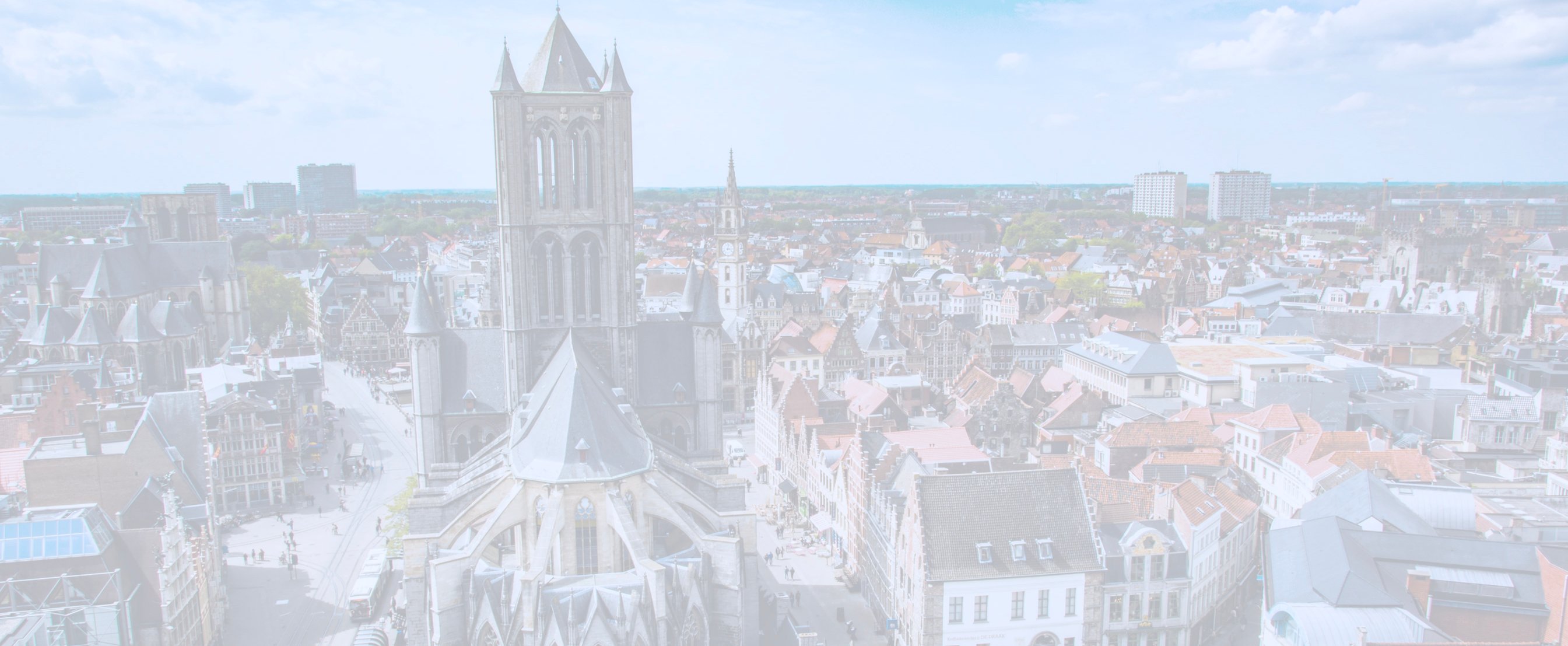 A faded out photo of Ghent, which is a city in Belgium. It has a huge cathedral in the foreground and is full of buildings.