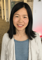Tamara Yu, a full stack engineer, has black hair and is wearing a white sweater over a green shirt.