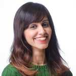 Maryam Umar has brown hair and is wearing a green sweater. She is Head of QA at a Fintech firm in London.