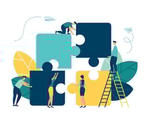 A group of people working as a team to push and lift large puzzle pieces into place. One mas uses a ladder. There are leaves.