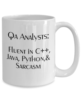 Mug reading "QA Analysts: Fluent in C++, Java, Python, and Sarcasm" 